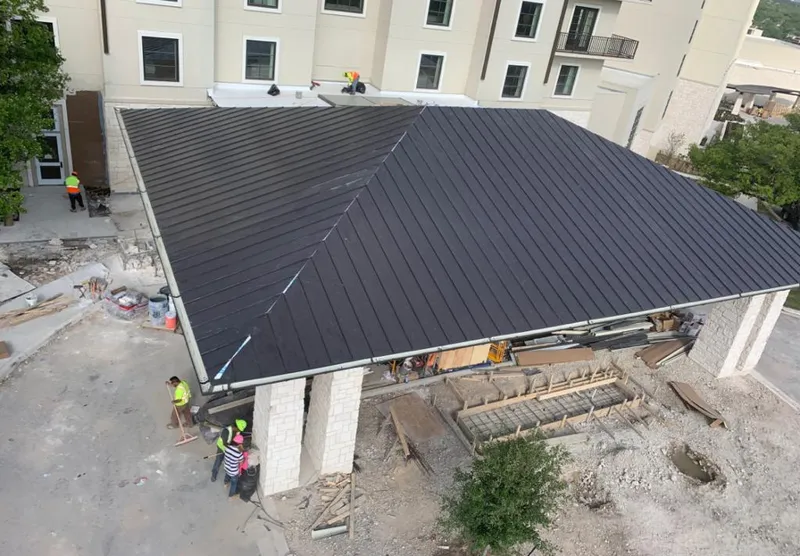 Metal roofing installation team working on a commercial building in Florence